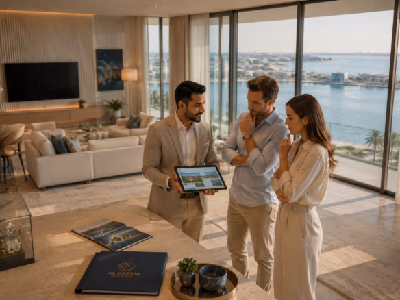Professional Al Zaeem Real Estate consultant guiding international buyers through a luxury waterfront apartment in Abu Dhabi during a private property viewing.